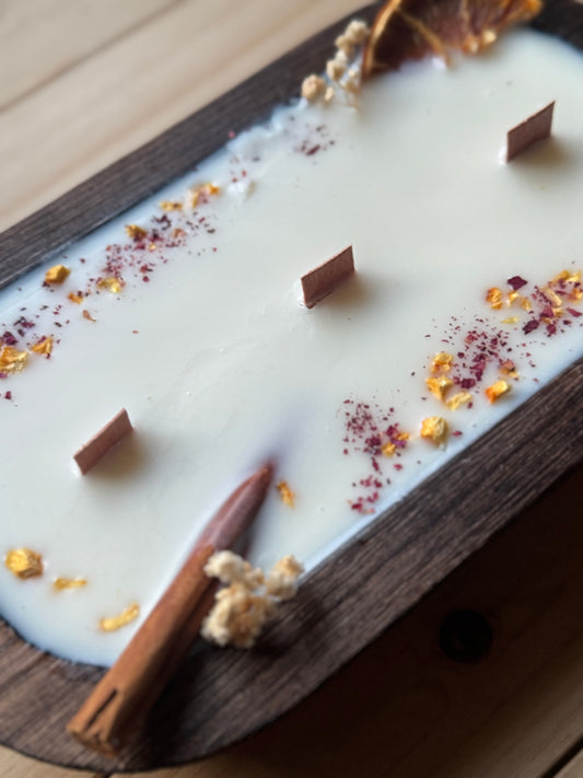 Vela canela y naranja en cuenco de madera