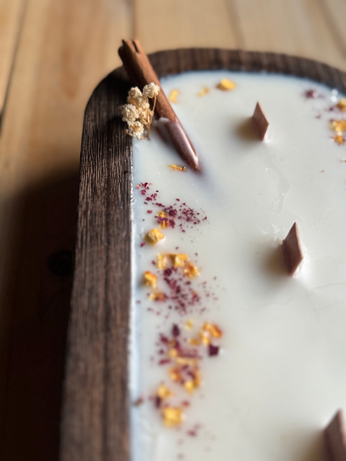 Vela canela y naranja en cuenco de madera