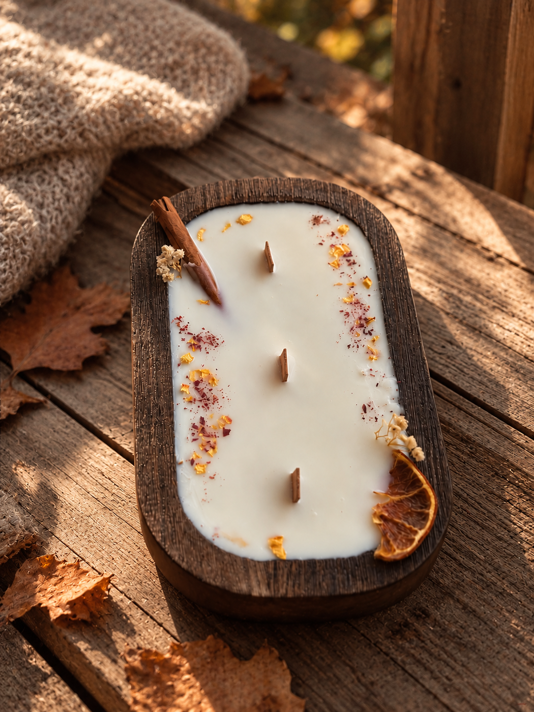 Vela canela y naranja en cuenco de madera