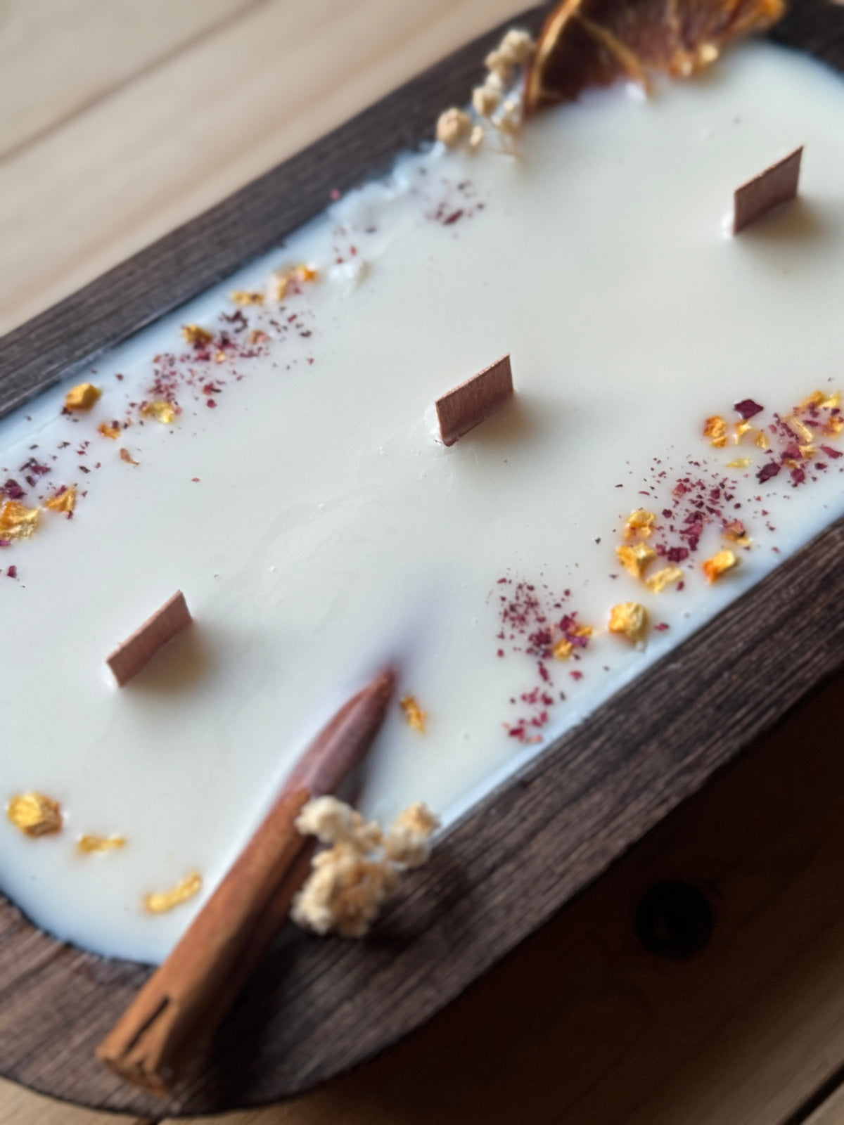 Vela canela y naranja en cuenco de madera