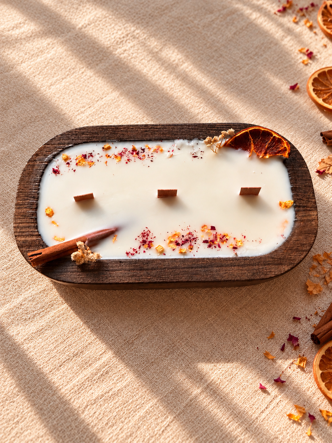 Vela canela y naranja en cuenco de madera